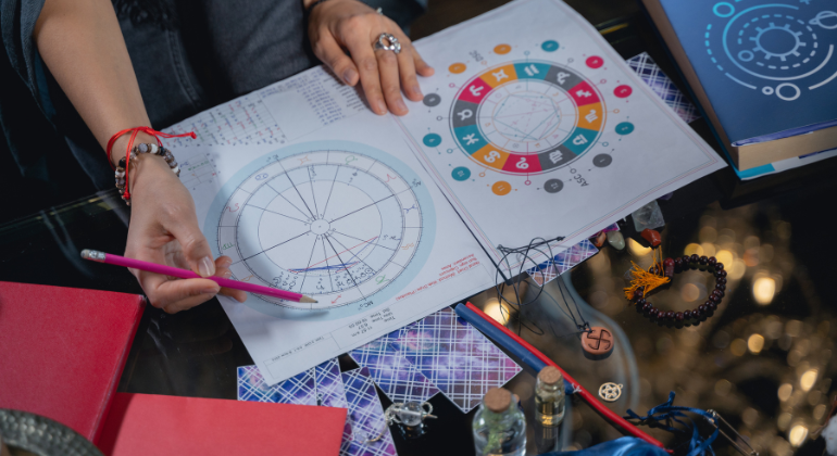 This image showcases a detailed astrology session with an astrologer analyzing a natal chart or birth chart. The circular chart reflects planetary placements, houses, and zodiac signs, used to provide insights into an individual’s personality, life events, and spiritual path. The colorful representation of zodiac symbols and planetary degrees indicates a structured astrological analysis.
The presence of spiritual elements like the Swastika symbol, prayer beads, and mystical tools highlights a holistic approach, combining astrology with spiritual practices.
This setup is ideal for in-depth astrological consultations, such as those offered by experts like Dr. Sauraabh Sinhha.