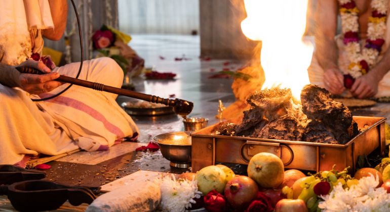 Indian Vedic astrology expert performing a sacred fire ritual (havan) with traditional offerings for spiritual alignment and planetary balance